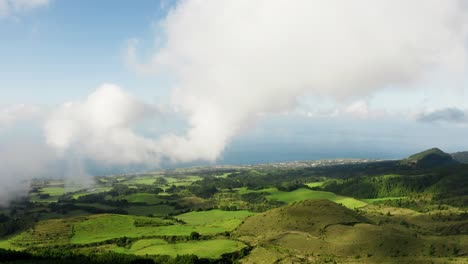 aerial reveal of pastures, forest patches and shoreline in são miguel azores