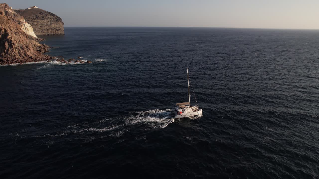vista aérea de la navegación en catamarán en el mar egeo cerca de la costa de la isla de santorini, grecia