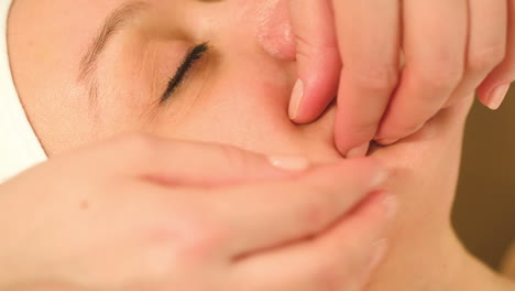 massage treatment of womans face at beauty spa