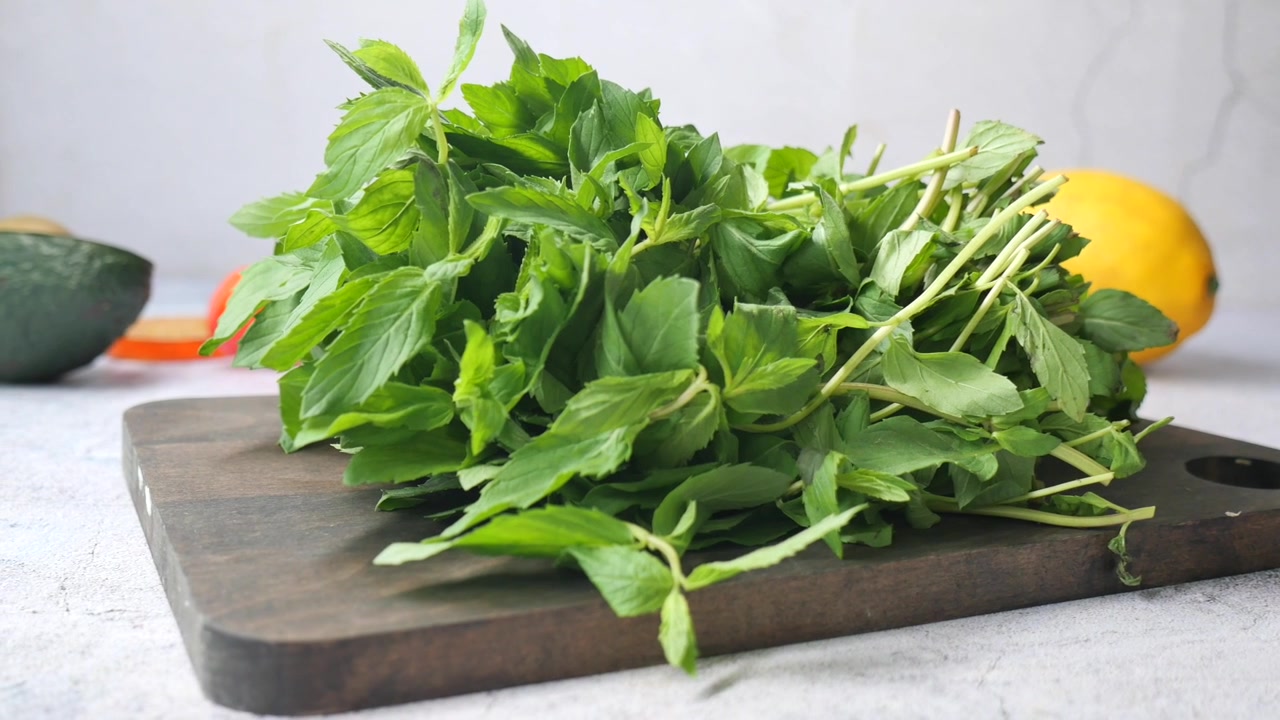 Fresco mazzetto di foglie di menta verde su un tagliere di legno