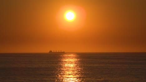 Un-Buque-De-Carga-De-Contenedores-Distante-O-Un-Petrolero-Viaja-Contra-El-Sol-Poniente-Al-Atardecer