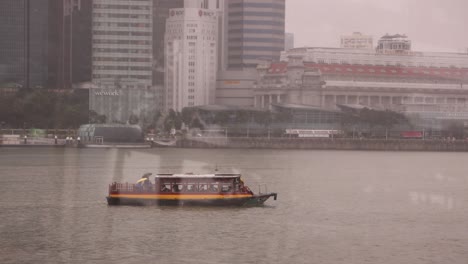 boat floating in the marina bay sands harbor in ultramodern cityscape of singapore, along the marina bay