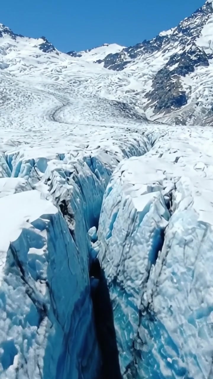 Splendido crepaccio glaciale: esplorando le maestose formazioni di ghiaccio blu e le fessure di un paesaggio glaciale sotto cieli azzurri e limpidi.