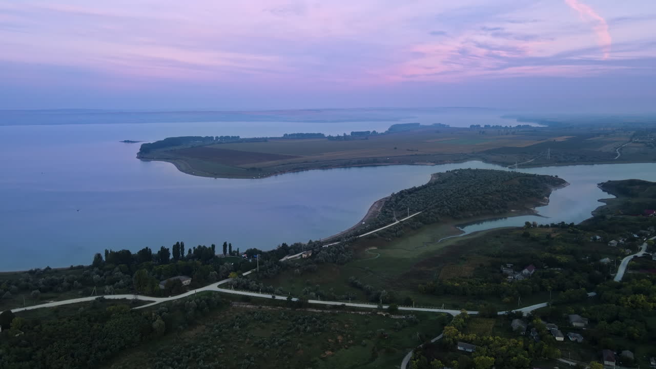 Aerial drone view of the Duruitoarea natural reservation in Moldova. River and fog in the air, hills and fields, village with roads and greenery