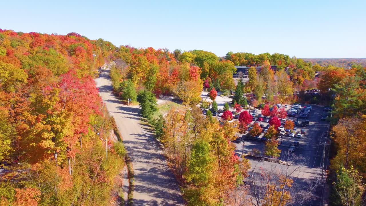 Vibrant autumn landscape with treetops filled with orange and yellow leaves in Val-des-Sources, Quebec