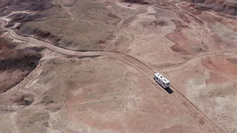 Una-Toma-Aérea-De-Un-Rv-Conduciendo-Fuera-De-La-Carretera-A-Través-Del-Desierto-De-Utah-En-Un-Viaje-Por-Carretera-Estadounidense