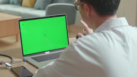 male doctor video call on laptop computer with green screen and consult client online, video in 4k