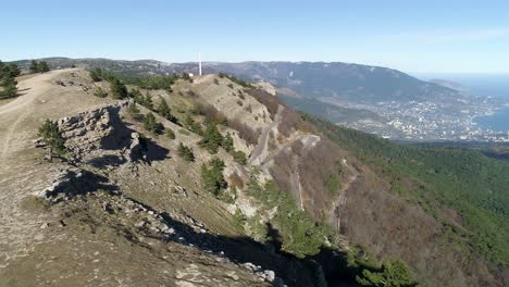 mountainous landscape with winding roads and coastal city view