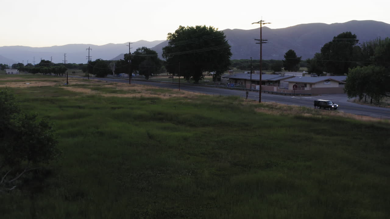 Vehicle Parked Along Quiet Rural Country Road Through Farming Village, Dusk