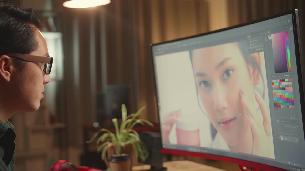 Asian Male Editor Works In Photo Editing Software On His Personal Computer, He Works At Night