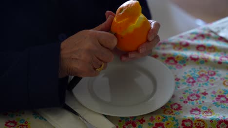 anciana pelando con precisión una naranja con un cuchillo
