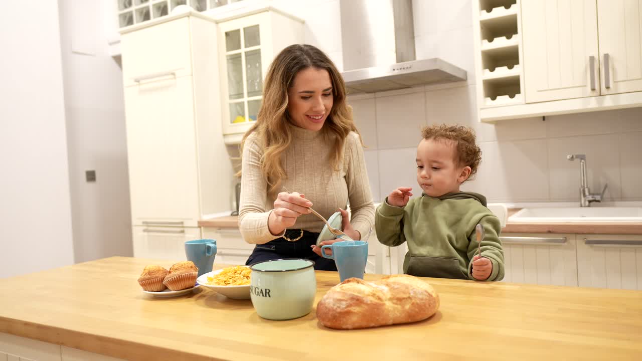 Madre e bambino felici che preparano la colazione in una cucina moderna.