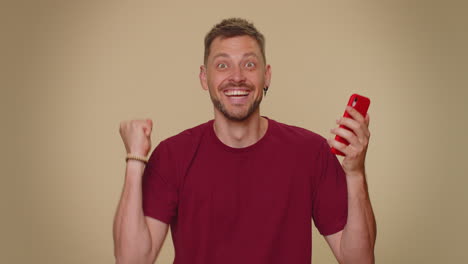 Happy-excited-joyful-man-winner-use-smartphone-found-out-great-big-win,-good-news,-lottery-jackpot