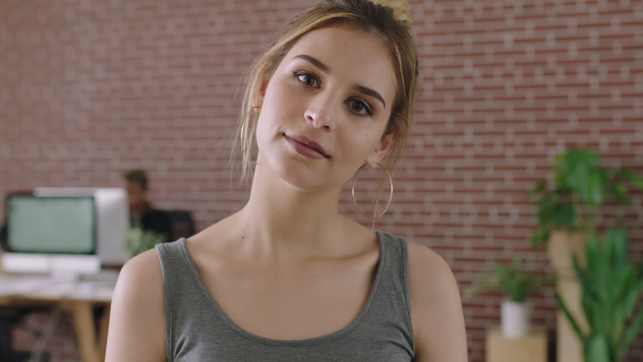 retrato de una hermosa mujer joven en una oficina contemporánea mirando pensativa a la cámara pensando contemplativo espacio de trabajo de oficina relajado