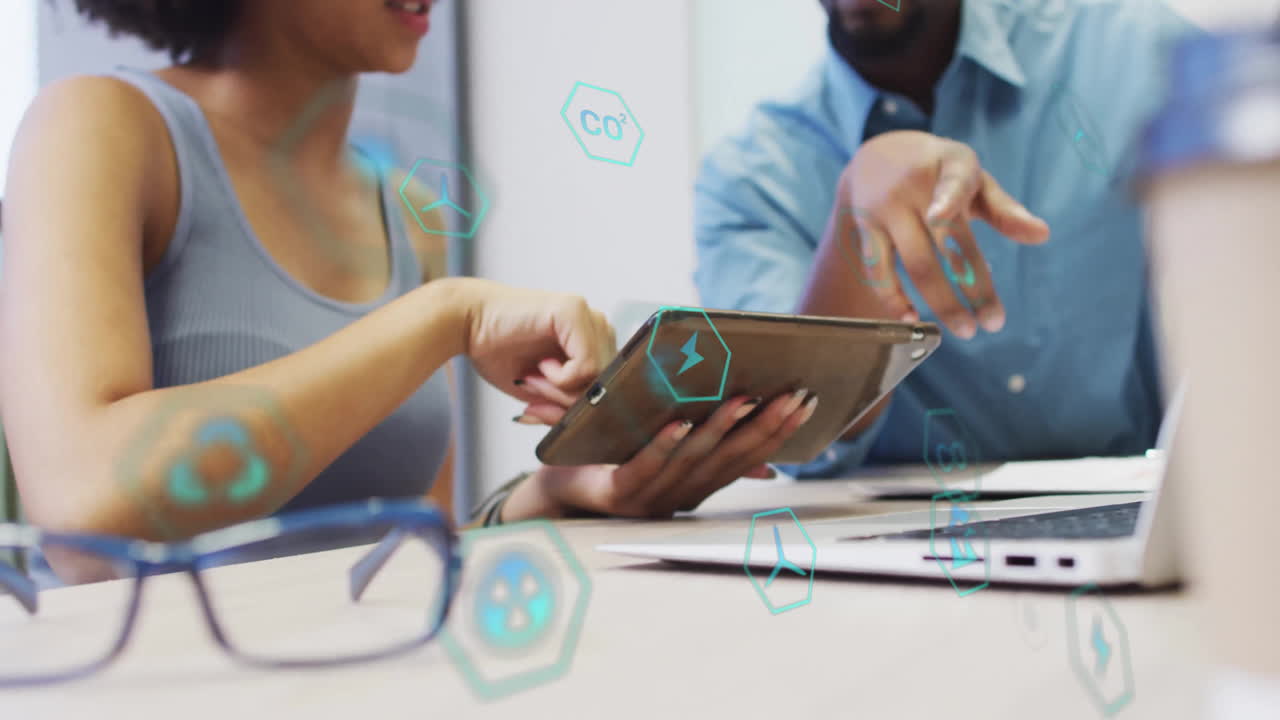 Discussing digital data, two people using tablet with animation overlay in office