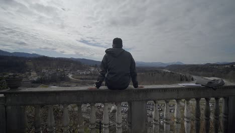 circular shot of young teenager sitting starring at marvelous landscape