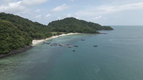 Tourists-arrive-at-pier-on-Pulau-Beras-Basah,-Malaysia,-by-tour-boat