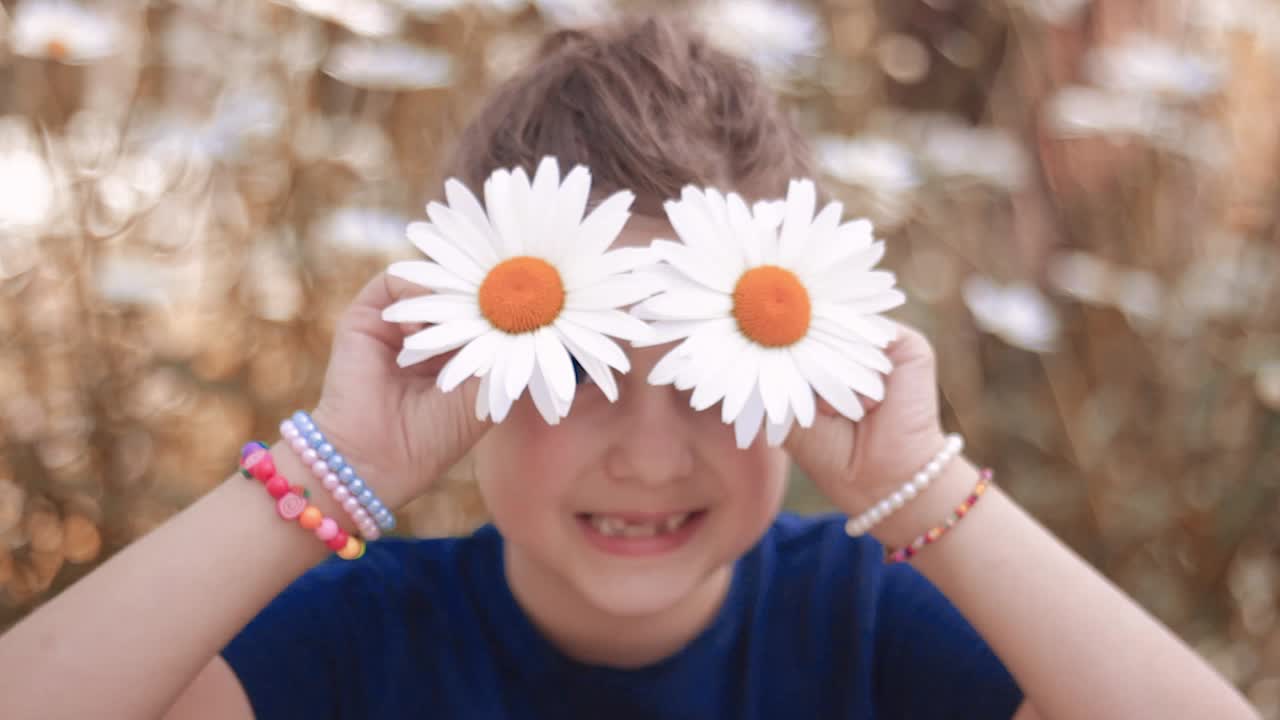 linda niña jugando con flores de margarita shasta, haciendo muecas, divirtiéndose