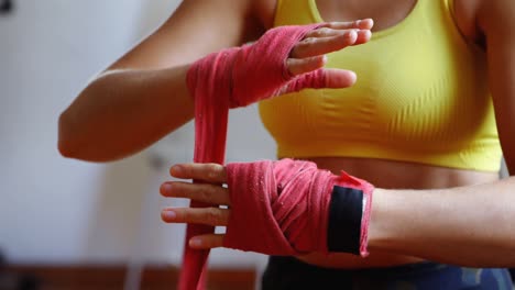 female boxer wearing hand wrap in fitness studio 4k