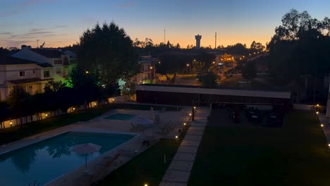 Night-time-lapse-of-cars-driving-by-past-pool-in-the-city-at-dusk