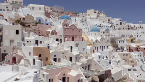 Antenne:-Pullback-Panoramische-Aufnahme-Der-Kirchen-Von-Oia-Auf-Santorini,-Griechenland-An-Einem-Sonnigen-Tag