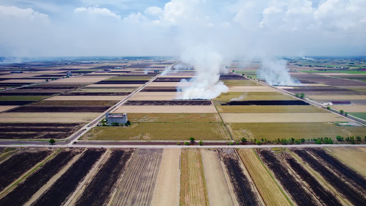 Aerial view of agricultural fields with smoke