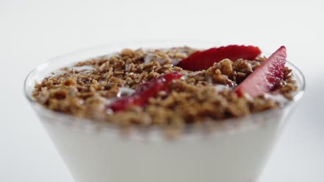 una fresa cae en el vaso parfait