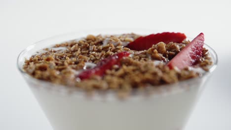 a strawberry falls in the parfait glass