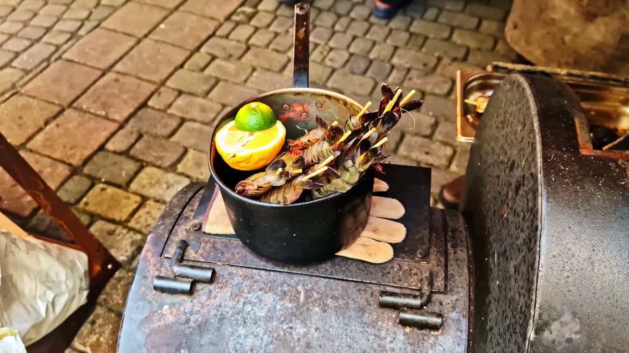 Grilled shrimp on skewers with a lime and lemon on a metal grill
