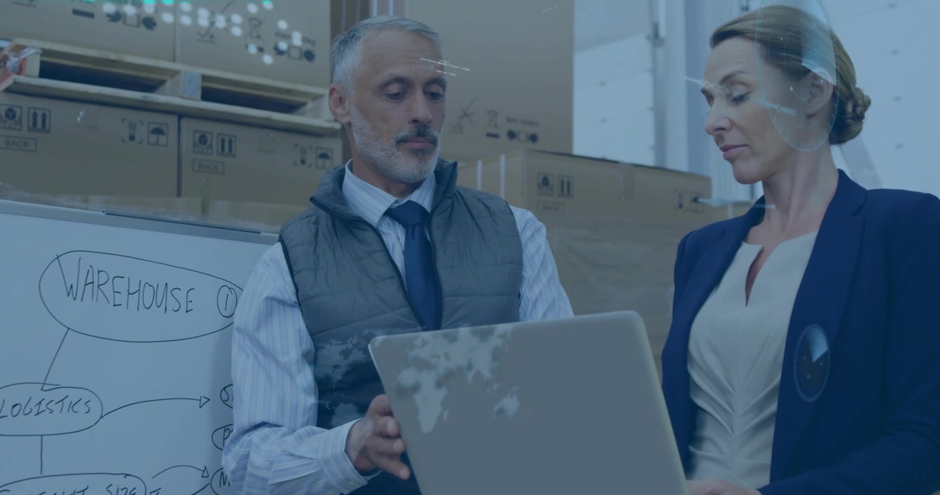 Uomo che digita sul laptop presenta un piano, donna che legge una bacheca logistica mentre animazioni in sovrapposizione appaiono sul laptop