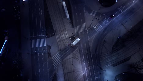 vista aérea nocturna vertical coches de tráfico en la intersección y luces de la calle y calles iluminadas en una ciudad moderna. avión no tripulado de tráfico.