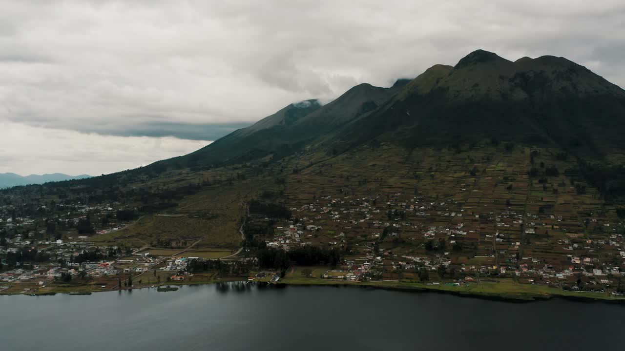 에콰도르의 오타발로 인근 배경에 임바부라 화산이 있는 호숫가 옆의 목가적인 산 파블로 델 라고 마을