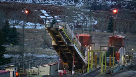 a close-up of bulk material discharge: a semi truck unloads wood products at a sawmill using a back-on truck dumper