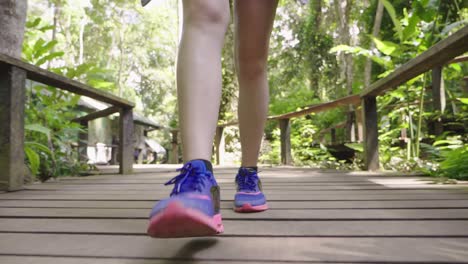 legs walking on wooden walk way, slow motion
