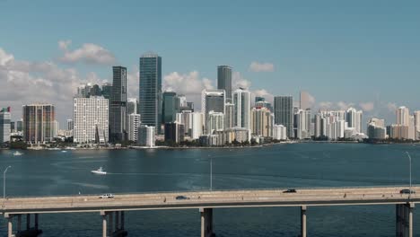 wide aerial drone flying over bridge - water towards downtown miami 4k