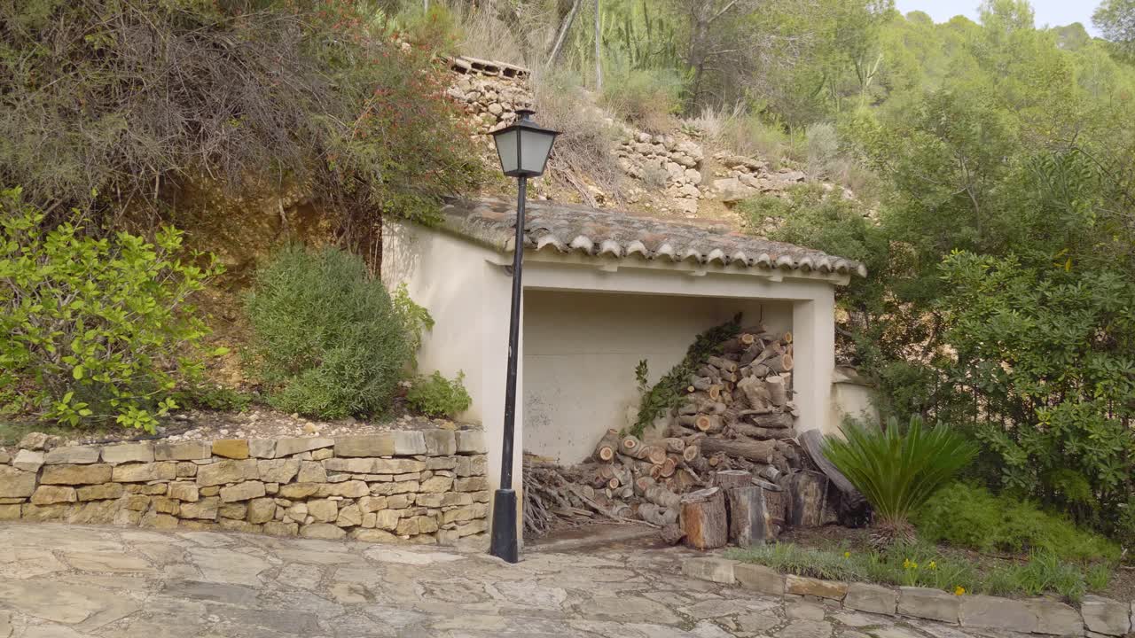 la cámara se desplaza para revelar una antigua cabaña de piedra que almacena leña en el pequeño pueblo de chulilla.