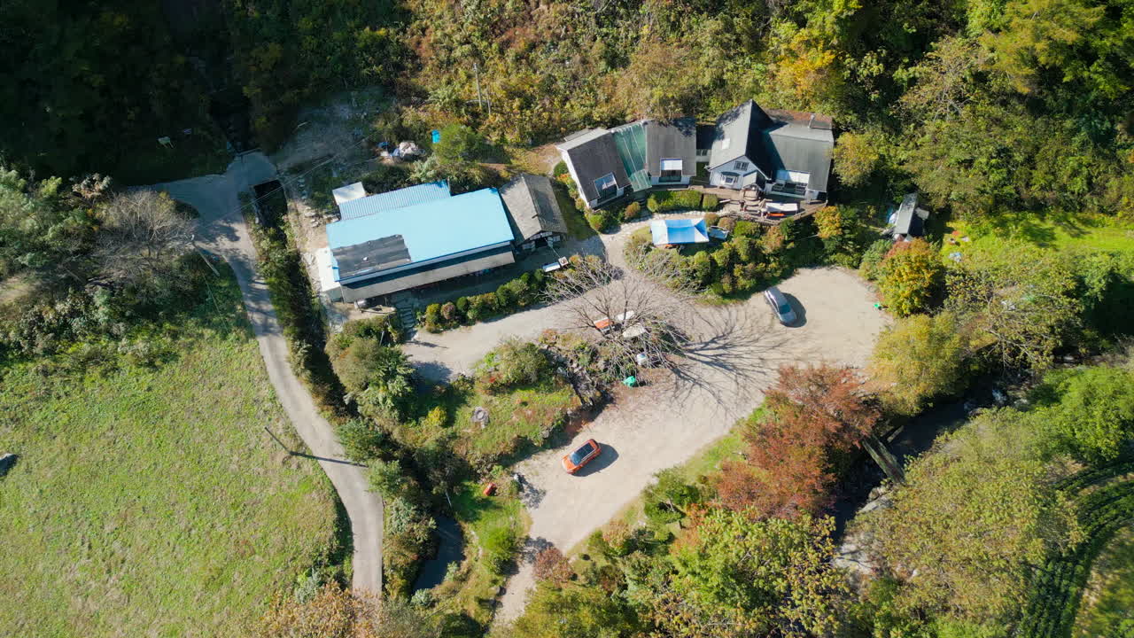A forward tracking shot approaching a small, isolated resthouse in the heart of the brilliant Pyeongchang autumn forest