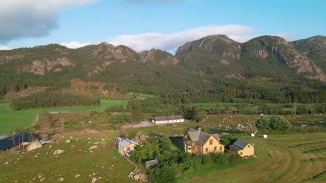 traditional norwegian houses in countryside in ryfylke, rogaland, norway with rocky mountainous landscape in background