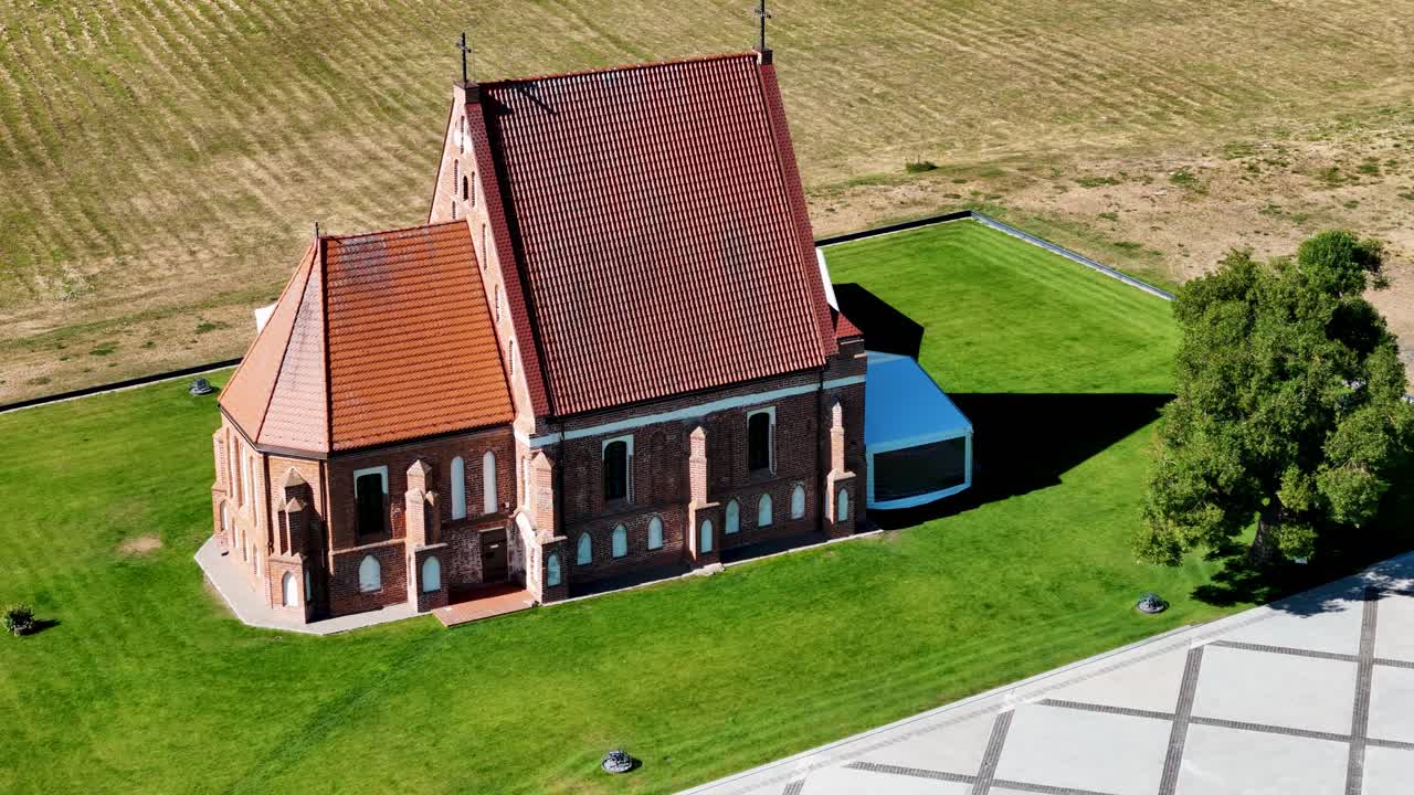 Red brick historical church in Zapykis, aerial orbit view
