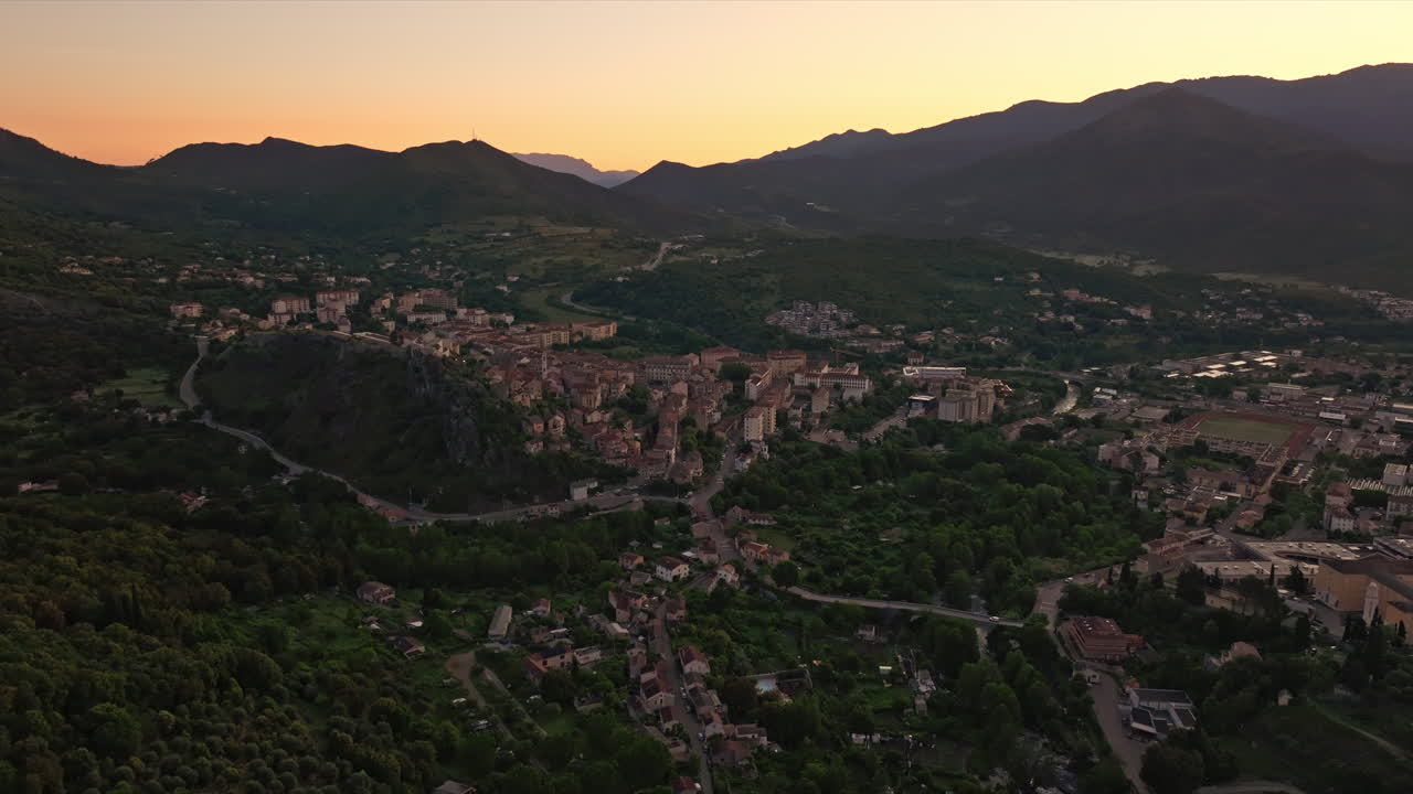 Aerial drone shot over the historic town of Corte, Corsica, France. High view of the old town and fortress overlooking the landmark on top of the hill. View of the scenic landscape and mountains