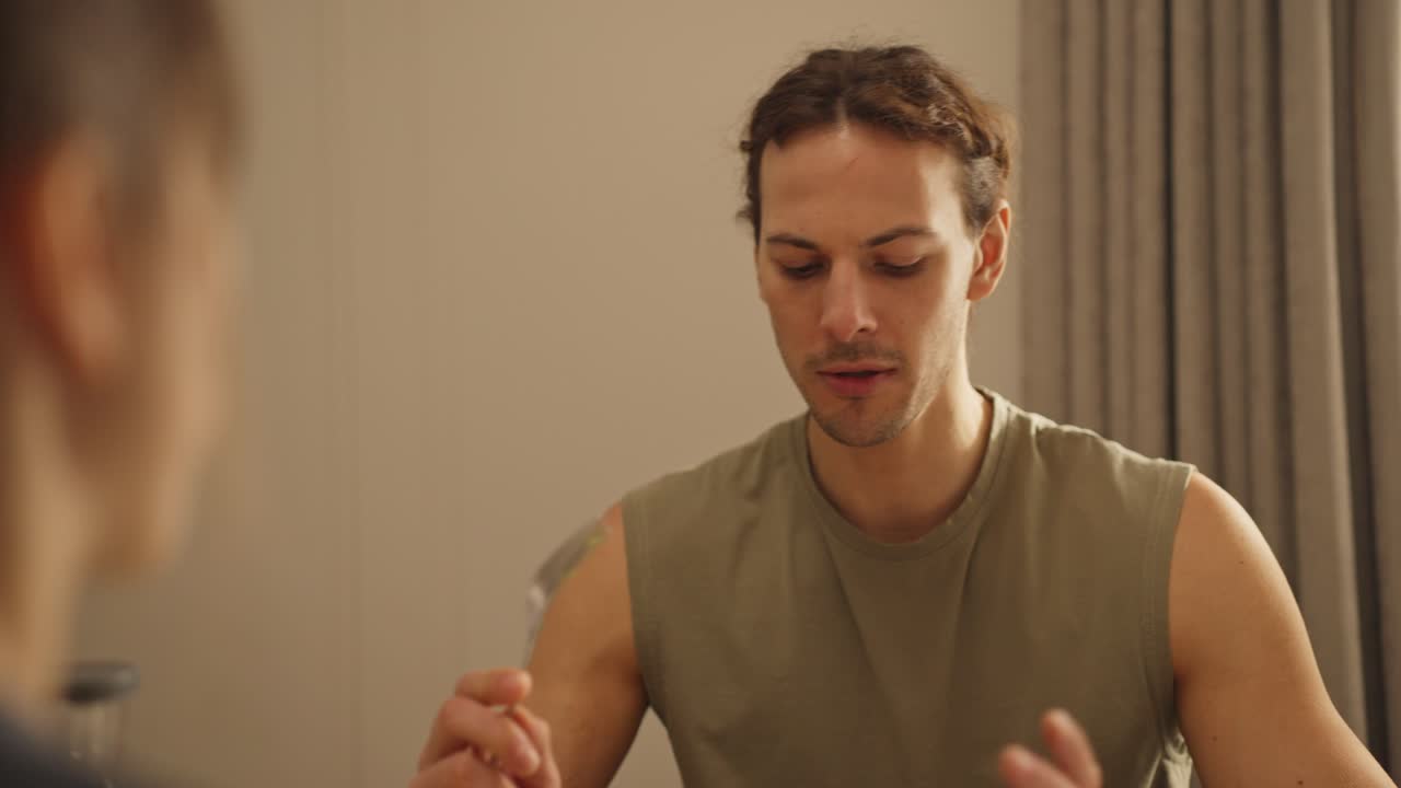 A man talking to another person indoors