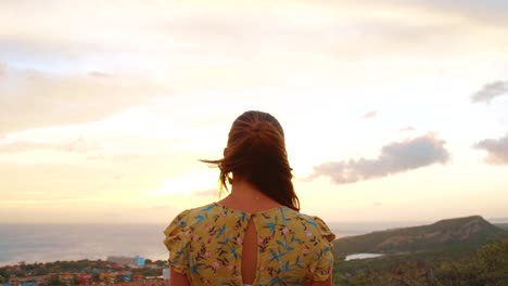 pedestal de una mujer atractiva con un vestido amarillo mirando al amanecer