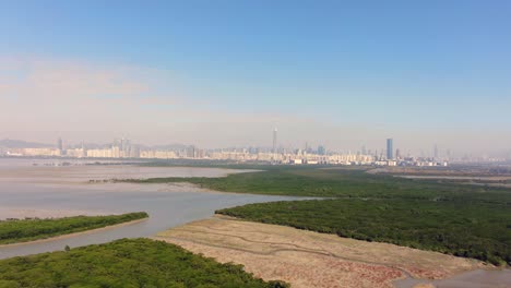 hong kong and shenzhen border line over hong kong rural houses with shenhzen skyline in the horizon, aerial view