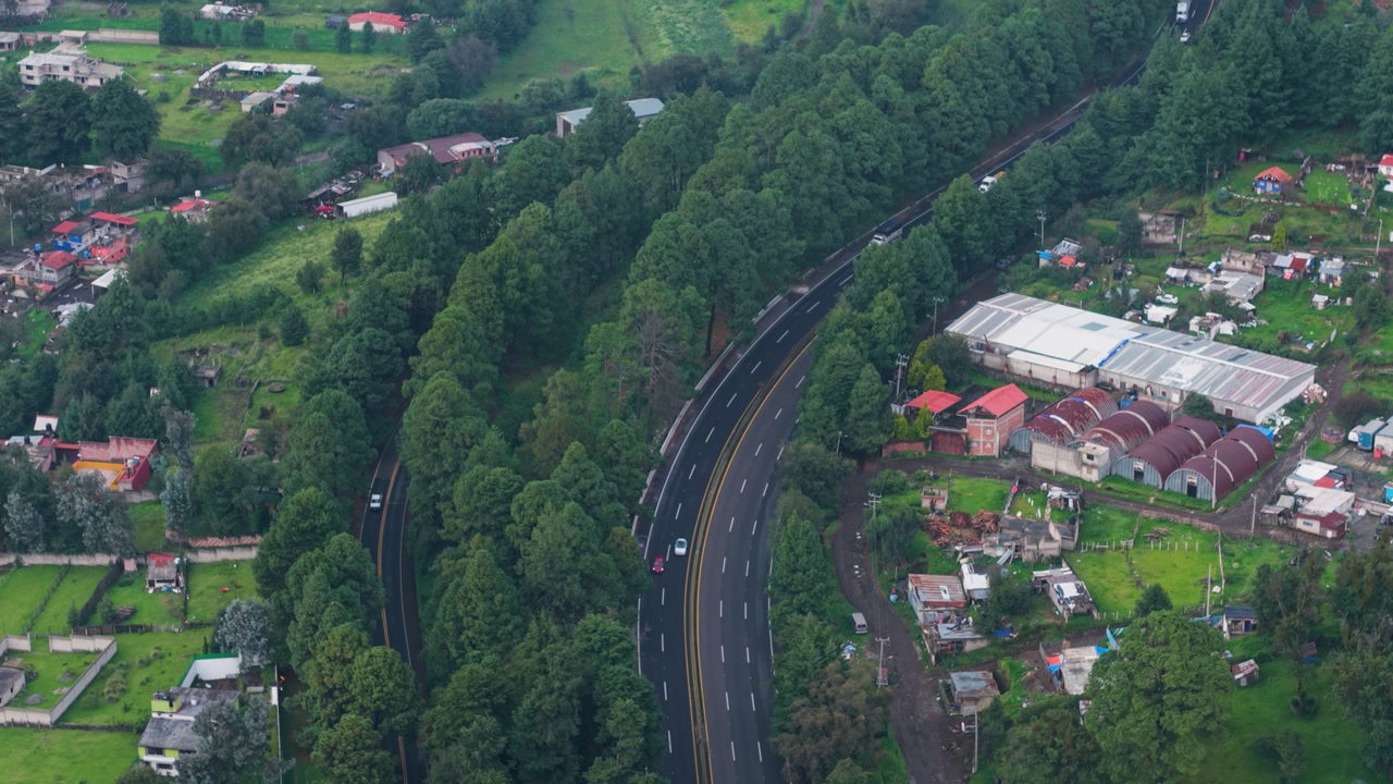 Aerial footage of highway surrounded by forest in Mexico on rainy day