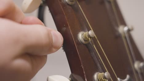 tuning the strings of a guitar in slow motion