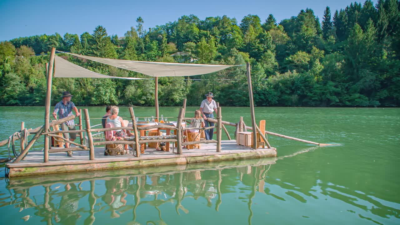 raftsmen steer with oars the log-raft calm relaxing waters of Drava river