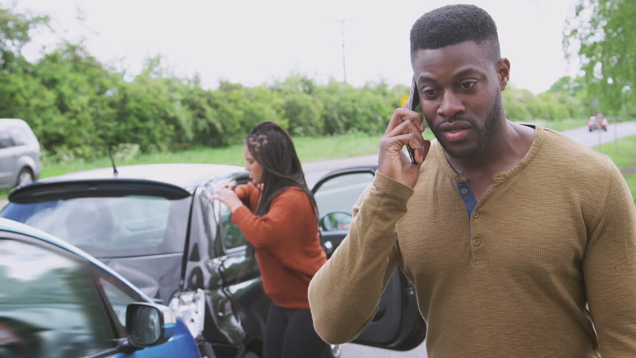 los conductores involucrados en un accidente automovilístico toman fotos de los daños y llaman a la compañía de seguros