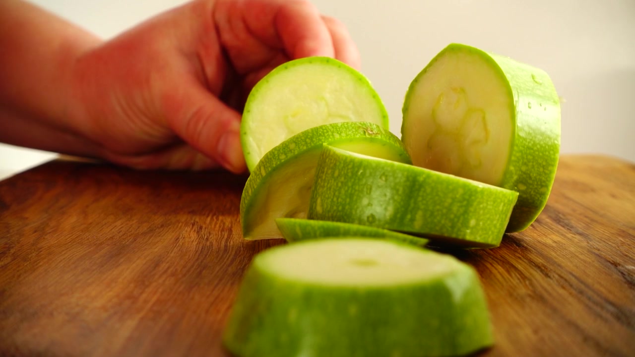 Il cuoco taglia le zucchine. Al rallentatore