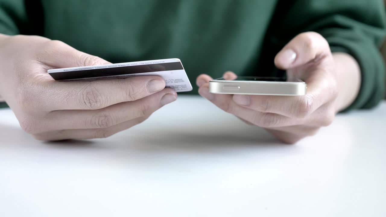 Female hands hold a white smartphone and a credit card, online banking, shopping 60 fps