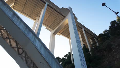 sunny view of arrábida bridge over the douro river in porto with lush greenery on a clear day